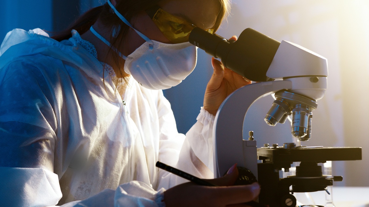 participação feminina na ciência - mulher analisando amostra em microscópio 