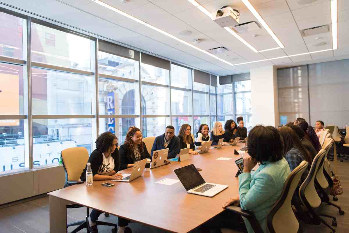 as-habilidades-do-futuro-do-trabalho-Várias pessoas estão sentadas interagindo em volta de uma grande mesa de trabalho.